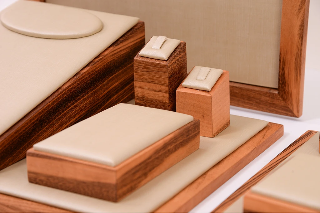 Conjunto de expositor para joias em madeira com detalhes em couro, ideal para exibir anéis, colares e brincos de forma elegante e organizada.